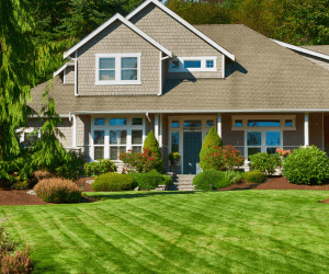Front view of a Craftsman-style single-family home with manicured lawn and covered porch.