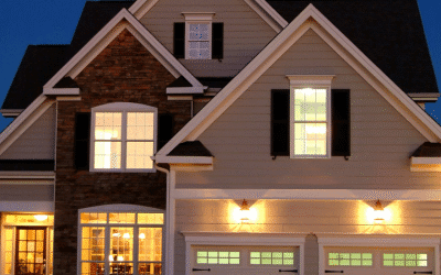 Two-story modern home with lit windows and garage at dusk in a suburban neighborhood