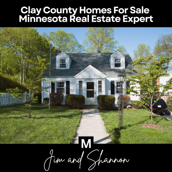 Banner featuring a classic single-family home with a manicured front yard and overlaid text “Clay County Homes For Sale Minnesota Real Estate Expert” above, plus the “M” logo and “Jim and Shannon” signature below
