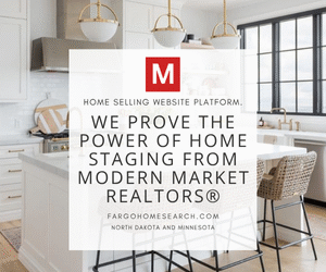 Bright staged kitchen showcasing modern white interiors with the message: “We Prove the Power of Home Staging from Modern Market REALTORS®.”