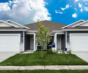 Modern twin home with matching garages under a sunny blue sky, ideal for Fargo-Moorhead home buyers.