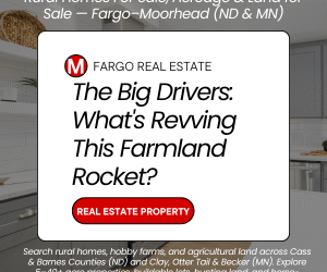 White real estate graphic banner from Fargo-Moorhead ND/MN broker advertising rural homes for sale, acreage, and land. Features bold red headline: "The Big Drivers: What's Revving This Farmland Rocket?" with "REAL ESTATE PROPERTY" in red below. Text at bottom promotes searching rural homes, hobby farms, and agricultural land across Cass & Barnes Counties (ND) and Clay, Otter Tail & Becker (MN). Clean modern kitchen background.